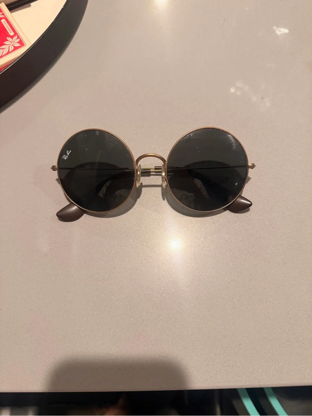 Raybans: Ja-Jo style. Rose gold frame. Black lenses I believe.